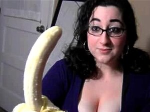 Brune à gros seins suce une banane