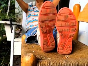 Une grand-mère coquine avec des lunettes montre ses jolis pieds