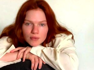 Une rousse à gros seins enlève ses vêtements et exhibe ses courbes