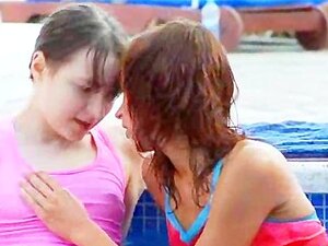 Des lezz mouillés s'embrassant au bord de la piscine