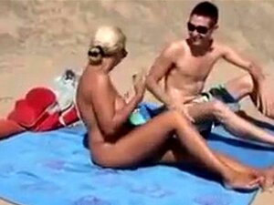 Femme mature aux gros seins filmée à la plage