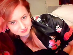 Une mignonne rousse fait un strip-tease